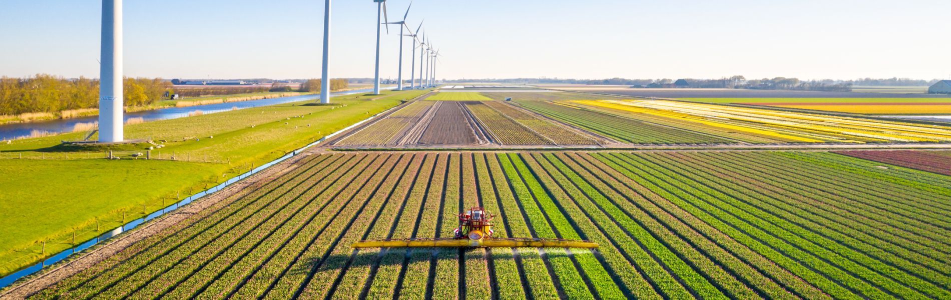 Farm equipment by windmills in the Netherlands