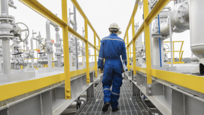 Man in hard hat walking through machinery