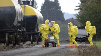 People in hazardous material suits by a truck