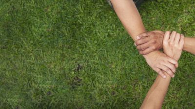 hands holding with green grass