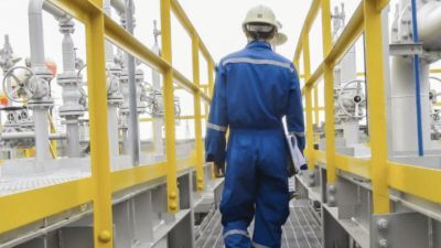 Man in hard hat walking through machinery